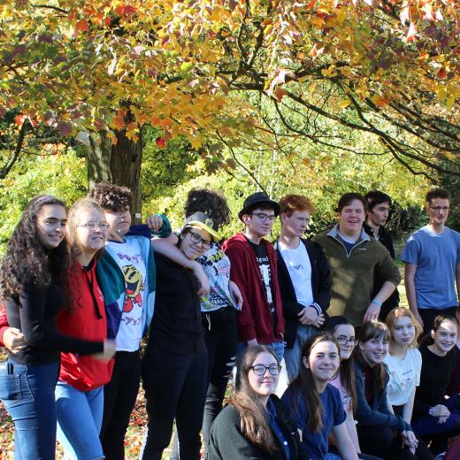 Group of young people under autumnal tree